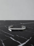 Silver open cuff bracelet on a black marble surface